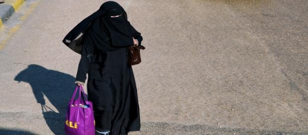 Woman in hijab carries the child's head Woman in hijab carries the child's head