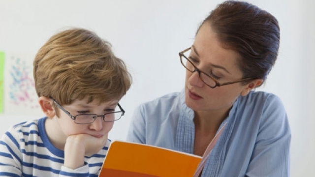 Un bambino legge un testo da un quaderno