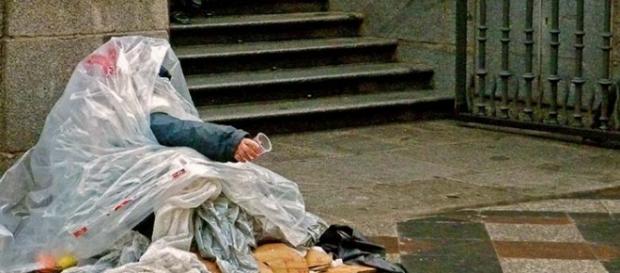 Un mendigo se guarece de la lluvia. Un mendigo se guarece de la lluvia.
