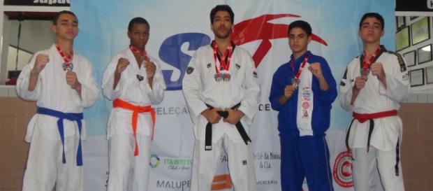Alunos exibem medalhas ao lado no mestre Alunos exibem medalhas ao lado no mestre