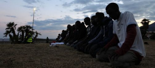 Musulmani improvvisano preghiera sulla spiaggia all'alba.