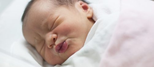 Un neonato che dorme nella culla.
