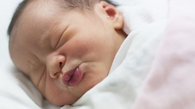 Un neonato che dorme nella culla.