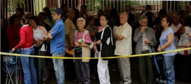 Ciudadanos haciendo cola para validar sus documentos y huellas Ciudadanos haciendo cola para validar sus documentos y huellas