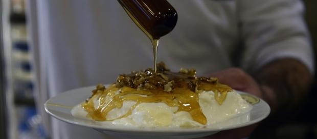 Atenas: cozinheiro serve iogurte com mel e nozes em restaurante Atenas: cozinheiro serve iogurte com mel e nozes em restaurante