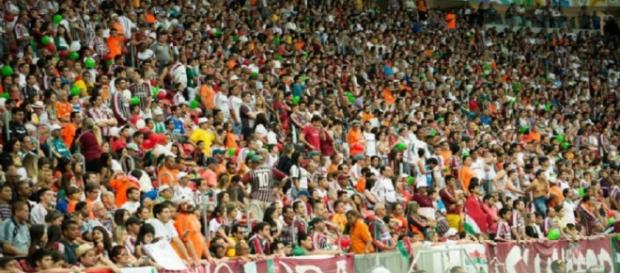 Torcida do Fluminense no Mané Garrincha, palco do jogo contra o Corinthians (Fonte: Site Oficial do FFC) Torcida do Fluminense no Mané Garrincha, palco do jogo contra o Corinthians (Fonte: Site Oficial do FFC)