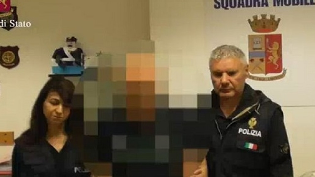 Il bidello della scuola media di Ragusa, scortato dalla Polizia di Stato. (Ansa)