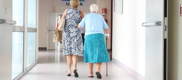 Una anciana acompañada por los pasillos de un hospital Una anciana acompañada por los pasillos de un hospital