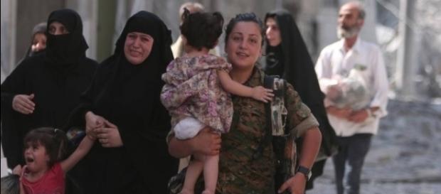 Combatente das Forças Democráticas Sírias ajudam famílias na libertação de Manbij, cidade que estava sob o controle do Estado Islâmico Combatente das Forças Democráticas Sírias ajudam famílias na libertação de Manbij, cidade que estava sob o controle do Estado Islâmico
