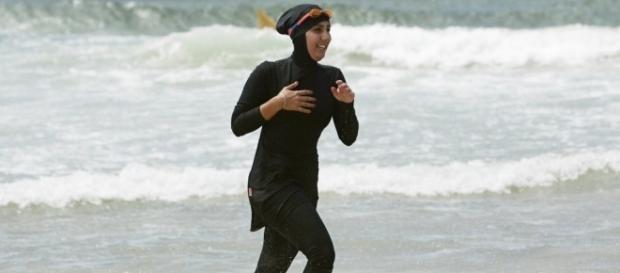 Une nageuse en burkini sur une plage Une nageuse en burkini sur une plage
