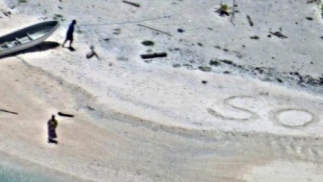 La foto dei due naufraghi che hanno scritto SOS sulla spiaggia