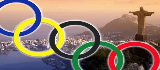 I 5 cerchi simbolo delle Olimpiadi e, sullo sfondo, Rio de Janeiro I 5 cerchi simbolo delle Olimpiadi e, sullo sfondo, Rio de Janeiro