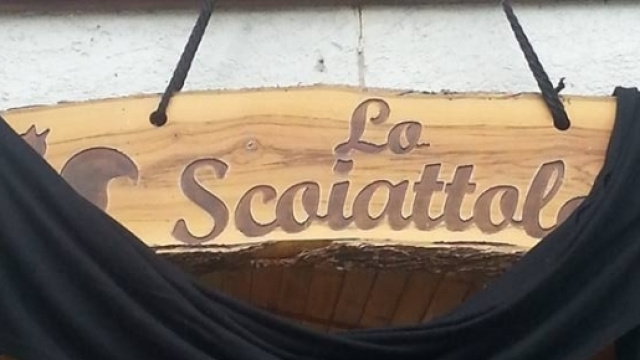 L'insegna del ristorante "Lo Scoiattolo" bardata a lutto