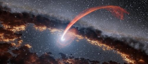 Illustrazione di un bagliore di luce proveniente dalla distruzione di una stella inghiottita da un buco nero. Foto credit: NASA/JPL-Caltech