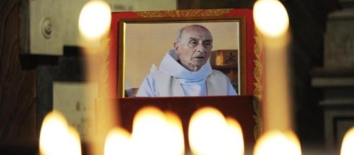 Una piccola foto e tante candele per ricordare padre Jacques Hamel.