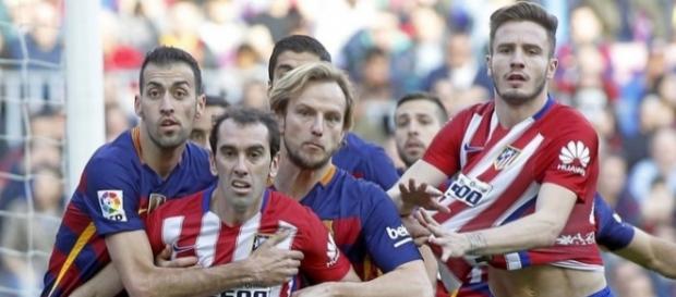 Jugadores del Barcelona y del Atlético luchan por rematar Jugadores del Barcelona y del Atlético luchan por rematar
