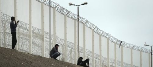 Migranti addossati alla barriere metalliche già esistenti. Foto BBC