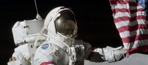 Eugene Cernan l'ultimo uomo sulla Luna tocca la bandiera americana nel 1972 nella regione lunare di Taurus Littrows