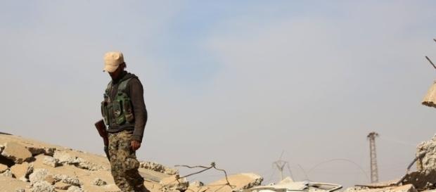 A US-backed fighter treads on rubble left by conflict inside Syria / nytimes.com A US-backed fighter treads on rubble left by conflict inside Syria / nytimes.com