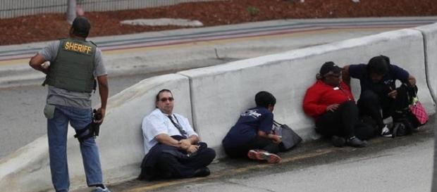 Pessoas se protegem do tiroteio Pessoas se protegem do tiroteio