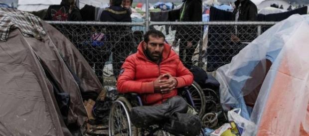 A man sitting on a wheelchair in a Greek refugee camp. A man sitting on a wheelchair in a Greek refugee camp.