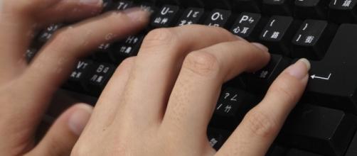 Woman typing /[Image via Adikos via Flickr]