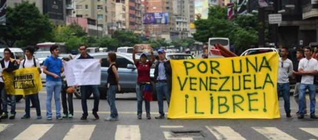 Manifestantes saem às ruas com cartaz em que se lê "Por uma Venezuela livre!" Manifestantes saem às ruas com cartaz em que se lê "Por uma Venezuela livre!"