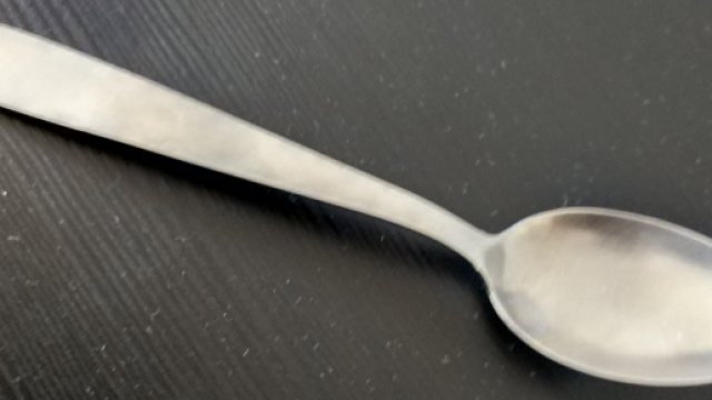 Cuillère de période moderne sur table noire et poussiéreuse. Métal inconnu