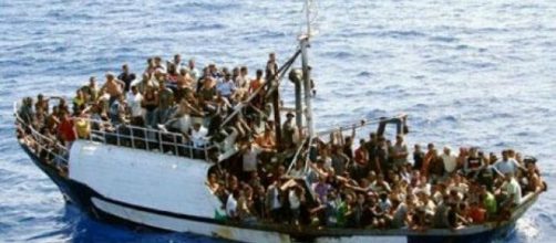 Un barcone colmo di immigrati pronti a sbarcare