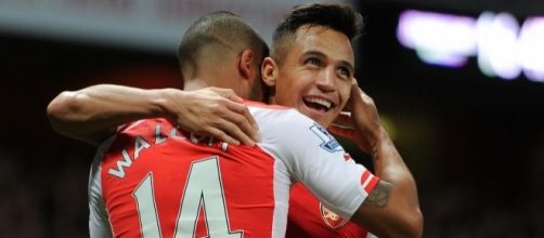 Arsenal player Theo Walcott celebrating with his teammate, Alexis Sanchez after scoring a goal. (Image via Aries Arsenal/Flickr)