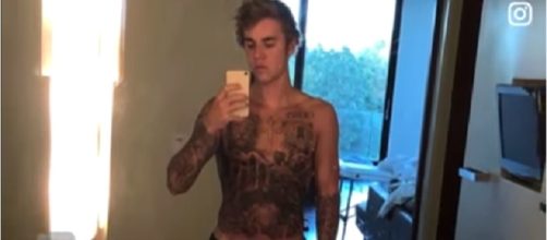 Justin Bieber shows off ‘shocking’ torso tattoo. Image via Entertainment Tonight/Youtube screenshot