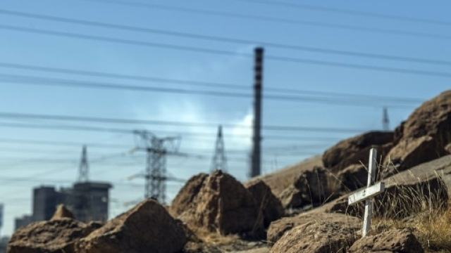 Un terreno con una croce e sullo sfondo una citt&agrave;