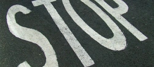 Il segnale di stop sull'asfalto stradale