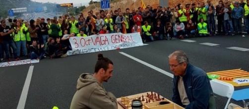 Trabajadores catalanes cortan una carretera mientras juegan al ajedrez. Fotografía de @PTalamanca