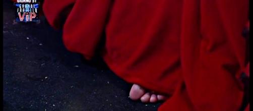 Il piede di Cecilia Rodriguez spunta dalla tenda rossa del confessionale