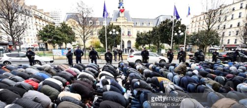 100 politicans protest the Muslim prayers that are taking place on the street in a Paris suburb.