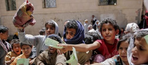 Yemenis present documents in order to receive food rations provided by a local charity, in Yemen's capital, Sanaa.