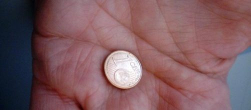 Una moneta da un centesimo tenuta in mano