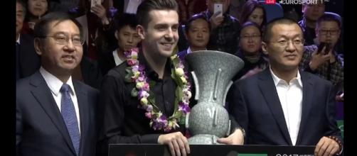 Mark Selby with the trophy in China holding a cheque for £150,000
