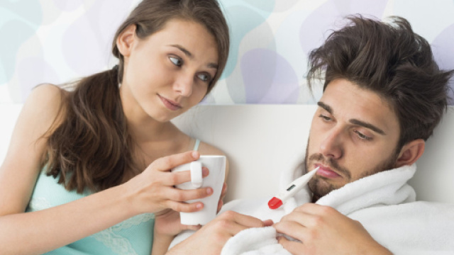 Un uomo a letto ammalato curato dalla compagna