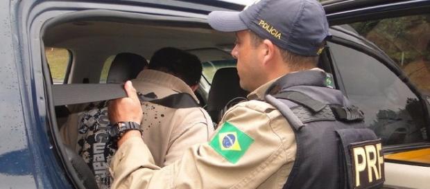 Agente da Polícia Rodoviária Federal efetuando atuação em rodovia. Agente da Polícia Rodoviária Federal efetuando atuação em rodovia.