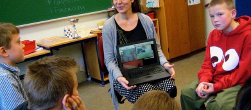 Teacher with laptop. - [Image credit: by Astrid Lomholt via Wikimedia Commons]