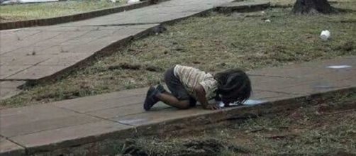 Niña guaraní bebiendo de un charco