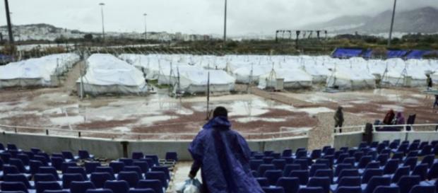 Un refugiado afgano carga bolsas de alimentos recibidos para su familia cerca de tiendas de campaña ubicadas en un campo de béisbol Un refugiado afgano carga bolsas de alimentos recibidos para su familia cerca de tiendas de campaña ubicadas en un campo de béisbol