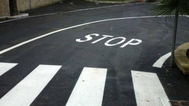 Il segnale dello stop sul manto stradale.