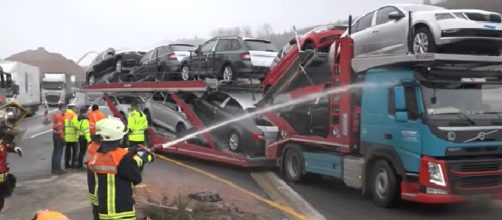 Vigile del fuoco spruzza acqua sui mezzi in transito dai quali le persone riprendono l'incidente con il telefonino