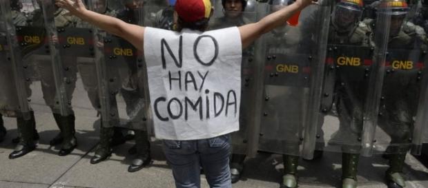Manifestante protesta diante de policiais do governo. Manifestante protesta diante de policiais do governo.