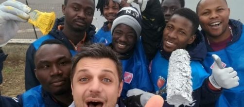 Gli immigrati del centro di accoglienza immortalati in un selfie dopo l'azione.
