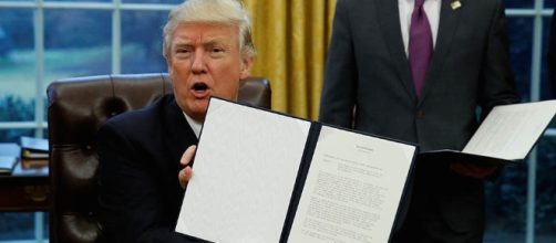 Donald Trump signs the order Photo credit to Vanhuy Nguyen