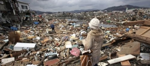 Donna che osserva il disastro causato dal maremoto in un villaggio del #Tohoku, #Giappone,